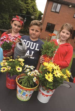 Ashwood Primary School at Parkgate held a bun sale and non uniform day to raise money for paint, compost, pots and plants to brighten up the garden of local Broadacres Care Home. Pictured potting plants at the home are pupils, from left to right: Nadia Zoka, Alaz Mete and Alyssa-Rose Godwin. 171220-1