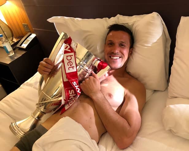 The morning after ... a picture from Richard Wood's own album as the skipper refuses to be parted from the play-off final trophy at the Hilton Hotel