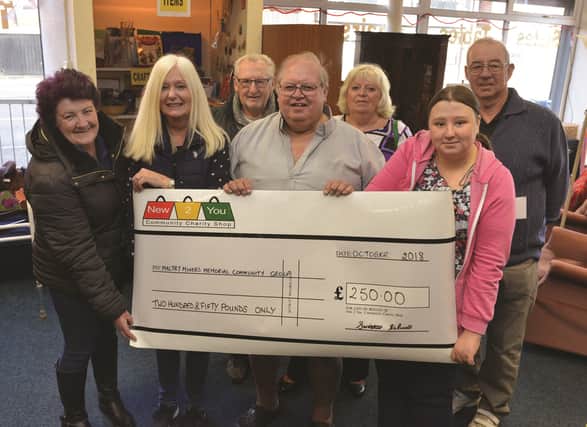 Shop manager Sue Webster (second left) and shop worker Emma Laverick (second right) hand over a cheque to ( left to right): Maltby Miners Memorial Community Group secretary Jasmine Fletcher, vice chairman David Fleming, chairman Bill Spilsbury, committee member Janet Brown and treasurer Dave Hart
