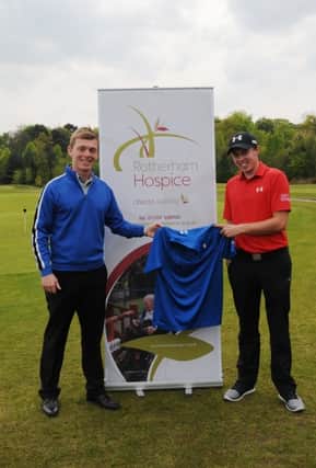 Sheffield golf ace Matthew Fitzpatrick (right) hands over a signed shirt for last year’s auction to College Pines professional Oliver Simms