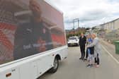 Natalie Robinson and her family watch Millers boss Paul Warne's key Covid-19 message on screen as the truck tours Rotherham this week.