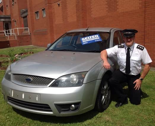 Chief Insp Paul Ferguson with one of the seized cars outside Main Street police station, Rotherham