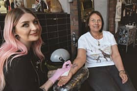 Natalie Yarrow who is having a giraffe tattoo in support of the Giraffe Conservation Trust, is pictured with Holy Ghost tattoo artist Alyx Wilson.