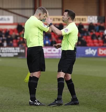 The assistant referee consulting with the referee after the incident during Saturday's game.