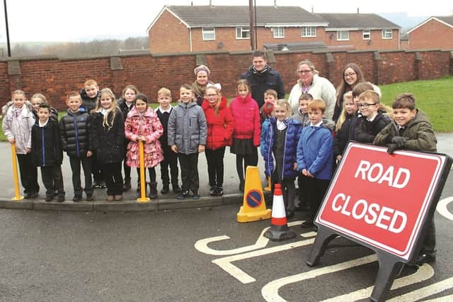head teacher, Jo Ayres, unveils the new bollards for new road safety measures. The head is seen with pupils from fountains and selby classes with teacher, Charlotte Wilson and TA's Jamie Barnes and Trisha Bateson. 180034-1