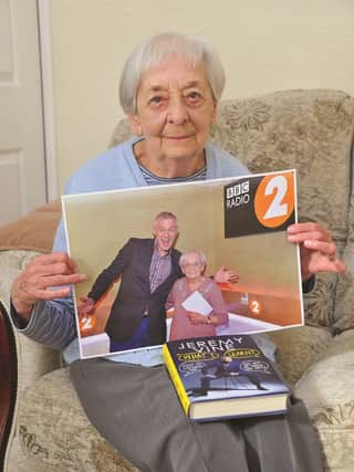 Jean at home in Clifton holding a photo of her with Radio 2's Jeremy Vine