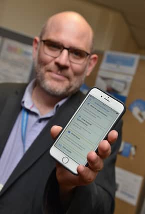 Sr Richard Cullen of Broom Lane Medical Centre shows the new Rotherham Health app.