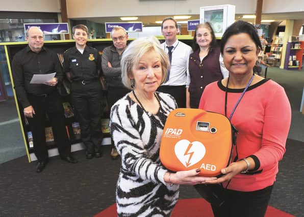 Presenting the machine on behalf of Start a Heart is Trish Lister (left) to Alnaar Clayton, customer service library manager. Also pictured looking on is Emma Scott from South Yorkshire Ambulance Service and Rotherham Heart Town representative (2nd left) along with library staff and volunteers. 172034-2