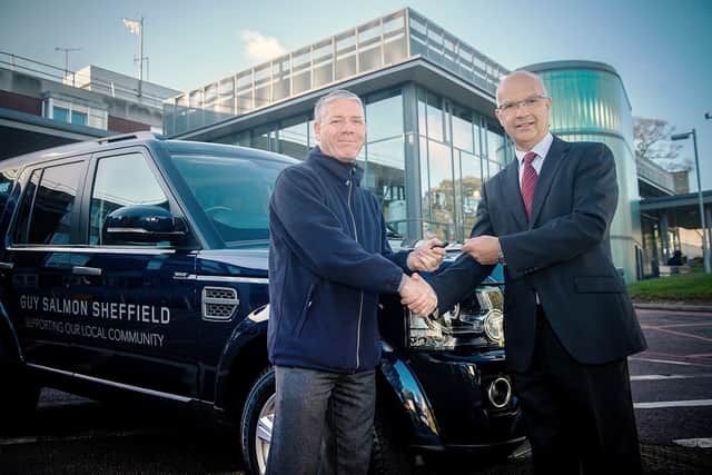 Mike Tyson, managing director of Guy Salmon Land Rover Sheffield (L), hands the Discovery’s keys to Chris Tobin, head of estates services (R).