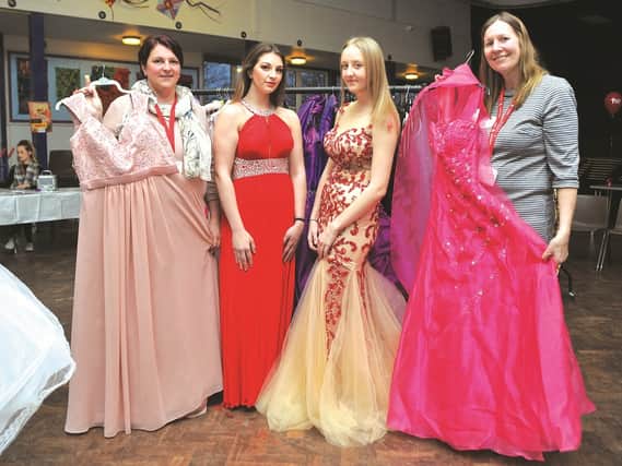 Seen with some of the dresses are organisers (left) Kirstie Pink and (right) Andrea Jenkinson, with students Jess Pink (16) and Tyler Cakebread (16), modelling a couple of dresses. 190310-1