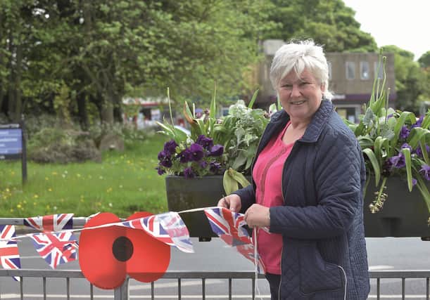 Cllr Sue Ellis puts up bunting and poppies in Wickersley