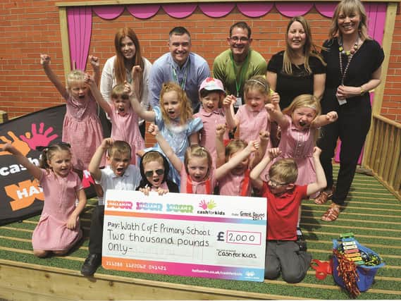 Pupils are seen with (back row, left to right) Leah England, Cash For Kids fundraising executive; Allan Ogle, Cah For Kids charity manager; Jim Staveley, Greener Places Ltd who built the stage; Lindsey Sandberg, deputy head teacher and Nicola McMullen, school governor. 