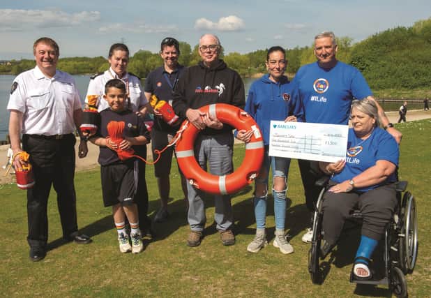 Presenting a cheque for £1500 to provide a new life saving station at the Waterfront Boat Club at Manvers, founders of the Sam's Army charity, Simon (second from right) and Gaynor Haycock (right) along with Jodi Ryalls (third from right). Also pictured are (from left to right), Ian Foster, South Yorkshire Fire and Rescue, Fleur Holland, of South Yorkshire Fire and Rescue with son Lucca, Si Bristow of the  RNLI and Chris Hawkesworth, president of Waterfront Boat Club. 220348