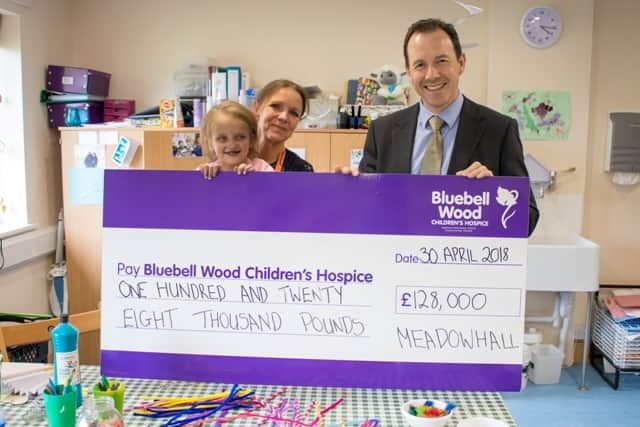 Bluebell Wood child Lily-Mai Davies celebrates the total in the charity’s craft room with chief executive Claire Rintoul and Meadowhall centre director Darren Pearce