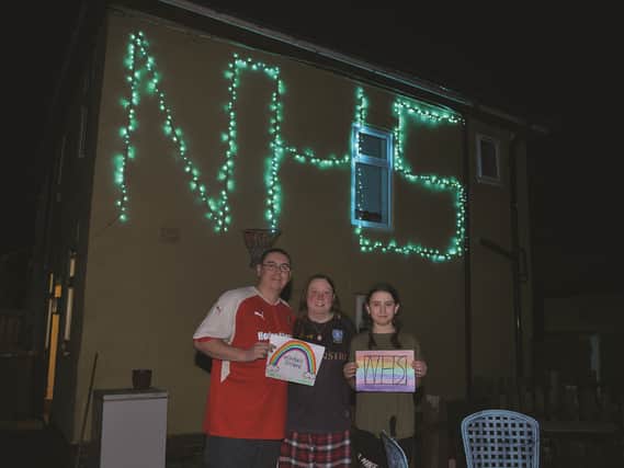 Michael and Laura Rowlinson and their daughter Holly show off their impressive NHS light display.