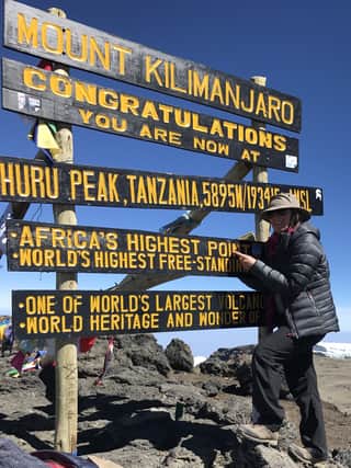 Angela at the peak of Mount Kilimanjaro.