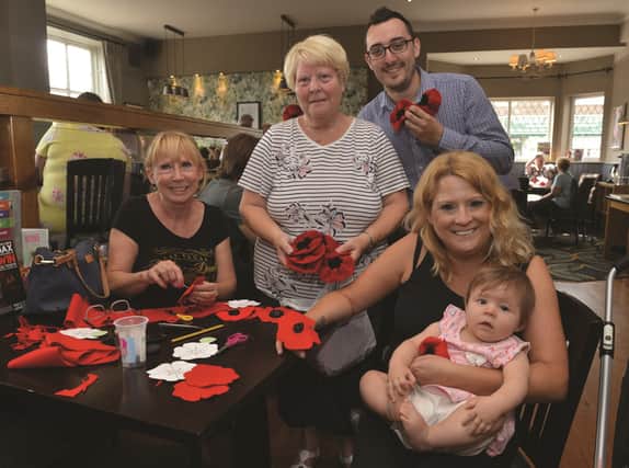 Members of the public were invited to the King Henry Pub at Bramley to make poppies to be displayed around the village. Event organiser and St Francis Church warden Sylvia Graham (centre) and the pub's assistant manager Chris Nutt are pictured with poppy makers Sandra Haith (left), Rachel Haith and baby Eira Fellowes. 184217-1