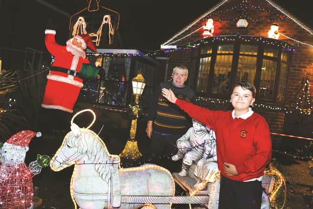 Martin Smith and his grandson Ryan Hobson, with some of the Christmas lights in the garden of his Rockingham Road home, which will raise funds for Bluebell Wood Children's Hospice. 184673-2