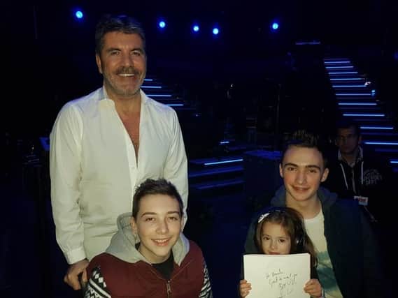 Timothy pictured with Simon Cowell, brother Christopher (17) and sister Amelia (3)