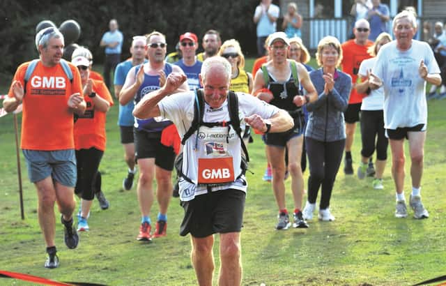 Ray Matthews crosses the finish line of his 75th marathon in as many days