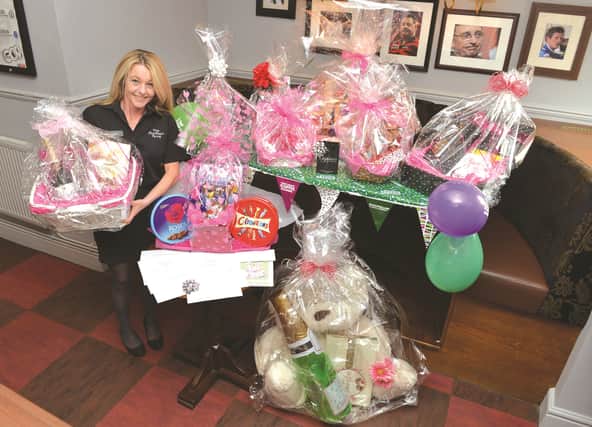 Montagu Arms bar staff member and fundraising events organiser Andrea Oliver, pictured with the haul of prizes which have been donated by local businesses for the pub's month of fundraising for Macmillan