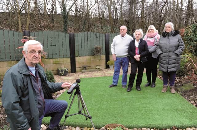 John Pashley with fellow residents in his garden in the shadow of the Parkway.