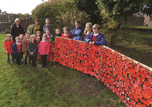Some of the children who made poppies are pictured with Thurcroft Infants School learning mentor Chris Nota (back left) and Willows School's head of art Inga Winson. 184547-1