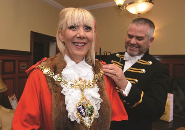 Mayor's attendant Tony Handsley attaches the chain of office to the robes of new mayor Cllr Eve Rose Keenan at the town hall 170837-1