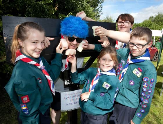 Group Scout leader Andrew Dudley takes the wet sponges at the Wickersley Gala and Fun Day. Members of 24th Rotherham Scout Group, Wickersley are pictured giving him a good soaking. From the left are Madison Rowe, Mollie Hogg, Elizabeth Wright(Scout Leader)and Joel Hogg. 151285-3