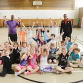Anthony Wilson (left) and Rotherham United player Darnelle Bailey-King with youngsters at the beginners' athletics sessions at Wath Comprehensive School. 171570