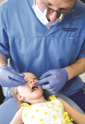 Dentist Steve Thompson checks the teeth of Josephina Thompson (2).