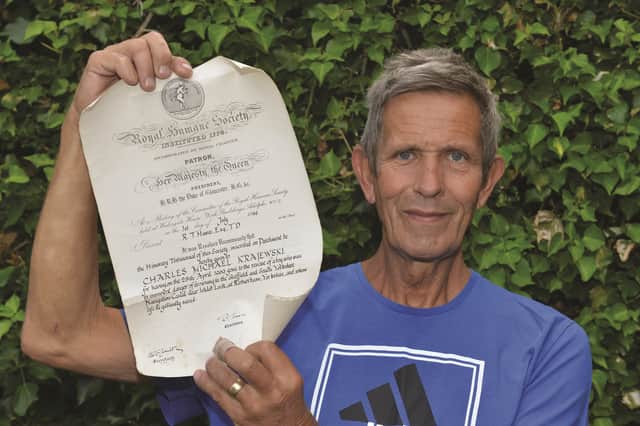 Charles Krajewski pictured with his certificate from the Royal Humane Society