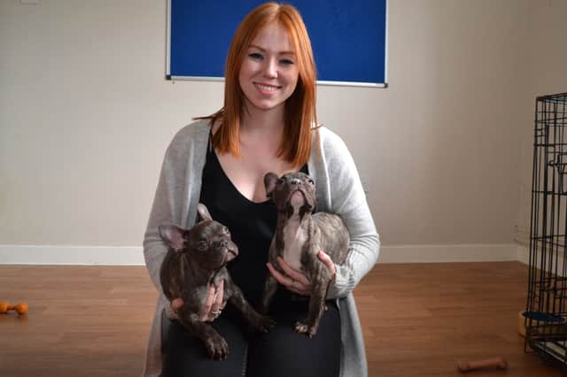 RSPCA rretail development coordinator Natalie Flanagan with French Bulldog puppies Bayley and Finn on the flooring donated by Flooring Superstore.