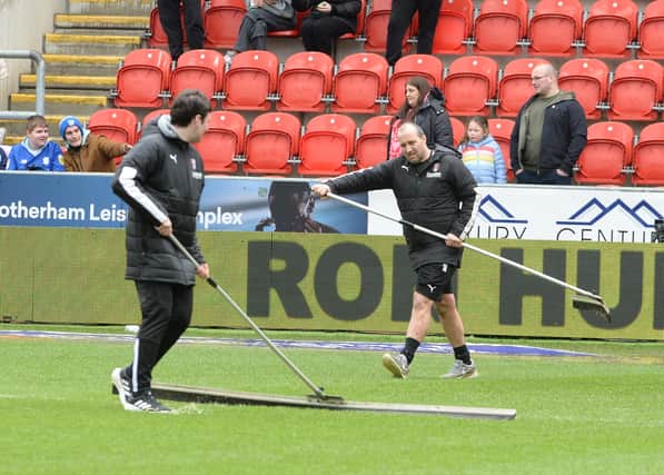 Grounds staff work to clear the pitch at New York Stadium after the deluge. Picture by Kerrie Beddows