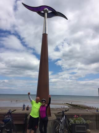 Paul and Sarah Harrison celebrate the end of their bike ride at the monument marking the end of the Trans-Pennine Trail in Hornsea.