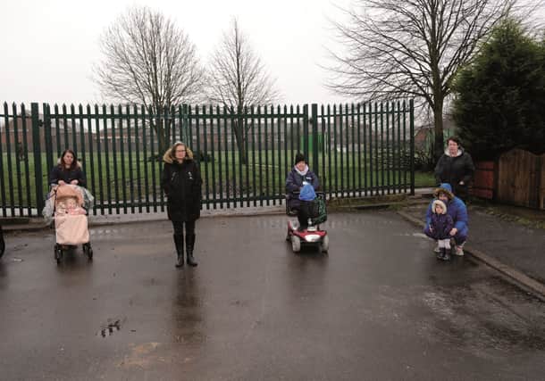 Taking of-fence, Kellie Sinderson with daughter Faith Jepson (left) along with residents from South Street, Thurcroft, who have been blocked from getting onto their playing fields by a new fence erected by the Parish Council. 210018-3