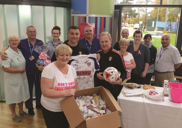 Staff nurse in theatres at Rotherham General Hospital Bobbie Evers who has breast cancer, has organised fundraising events in support of breast cancer services. A raffle was held in the reception area of Rotherham Hospital recently and Bobbie (front left) is pictured with Rotherham United's Richie Barker (fourth left) and John Breckin (sixth from right) who drew the raffle, staff and supporters. 171812-1