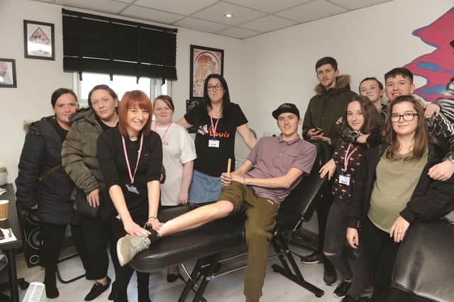Seen having his leg waxed is Drew Connell by Terri Pearce of Knot Just Hair, along with family and friends of the S62 Tattoo parlour. 184606