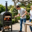 The portable outdoor pizza oven bundle includes a pizza stone, peel, cutter and integrated thermometer for garden cooking