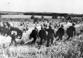 Police escorting picketers away from their position near the Orgreave Coking Plant near Rotherham in 1984 (PA)