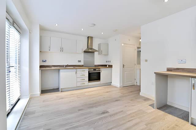 The stylish open-plan kitchen and dining area features sleek cabinetry, integrated appliances and elegant work surfaces