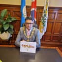The Mayor with his card which is on display in his office 