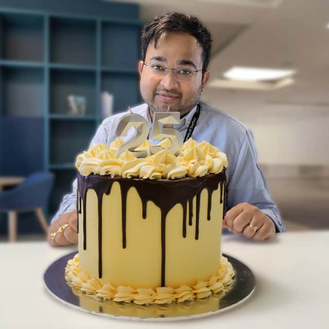 Great British Bake Off winner Dr Rahul Mandal with his showstopper - the official AMRC 25th birthday cake.