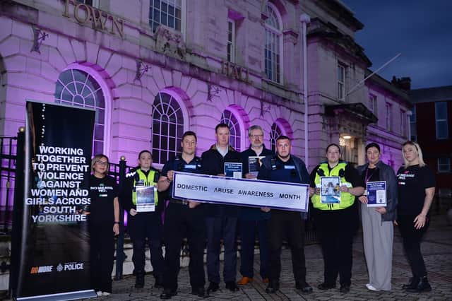 Rotherham Borough Council and South Yorkshire Police representatives pictured outside Rotherham Town Hall, which has been lit up purple in support of Domestic Abuse Awareness Month