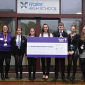 Lisa McCall, head of school, presenting the cheque to Bluebell Wood regional fundraiser Hannah Goulding (far left), with school pupils