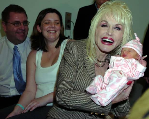 Dolly Parton meets baby Emma Jarman at Rotherham Hospital as her parents Shane and Claire look on. Dolly was in Rotherham to launch a reading scheme.