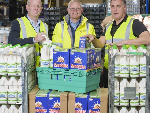 Jonathan Dixon, vice president  of sales at Arla, Simon Millard,  director of food at FareShare, and Andrew Shaw, supply chain director for UK and Ireland at Nestlé at FareShare's distribution centre in Wombwell.Photo credit: Dominic Lipinski/PA Wire