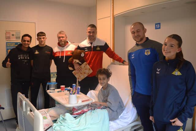 Club Doncaster (Rovers, Belles and Rugby League) giving a gift to a young patient on the Children’s Ward at Doncaster Royal Infirmary